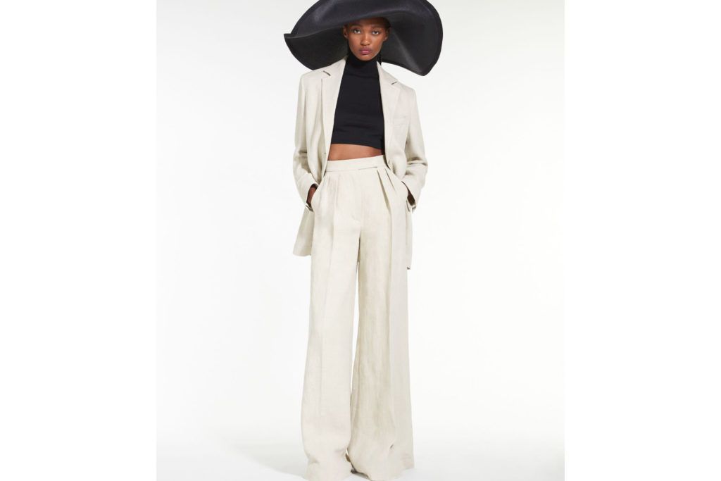 Ecru wide-leg linen trousers paired with a black shirt and a matching linen blazer.