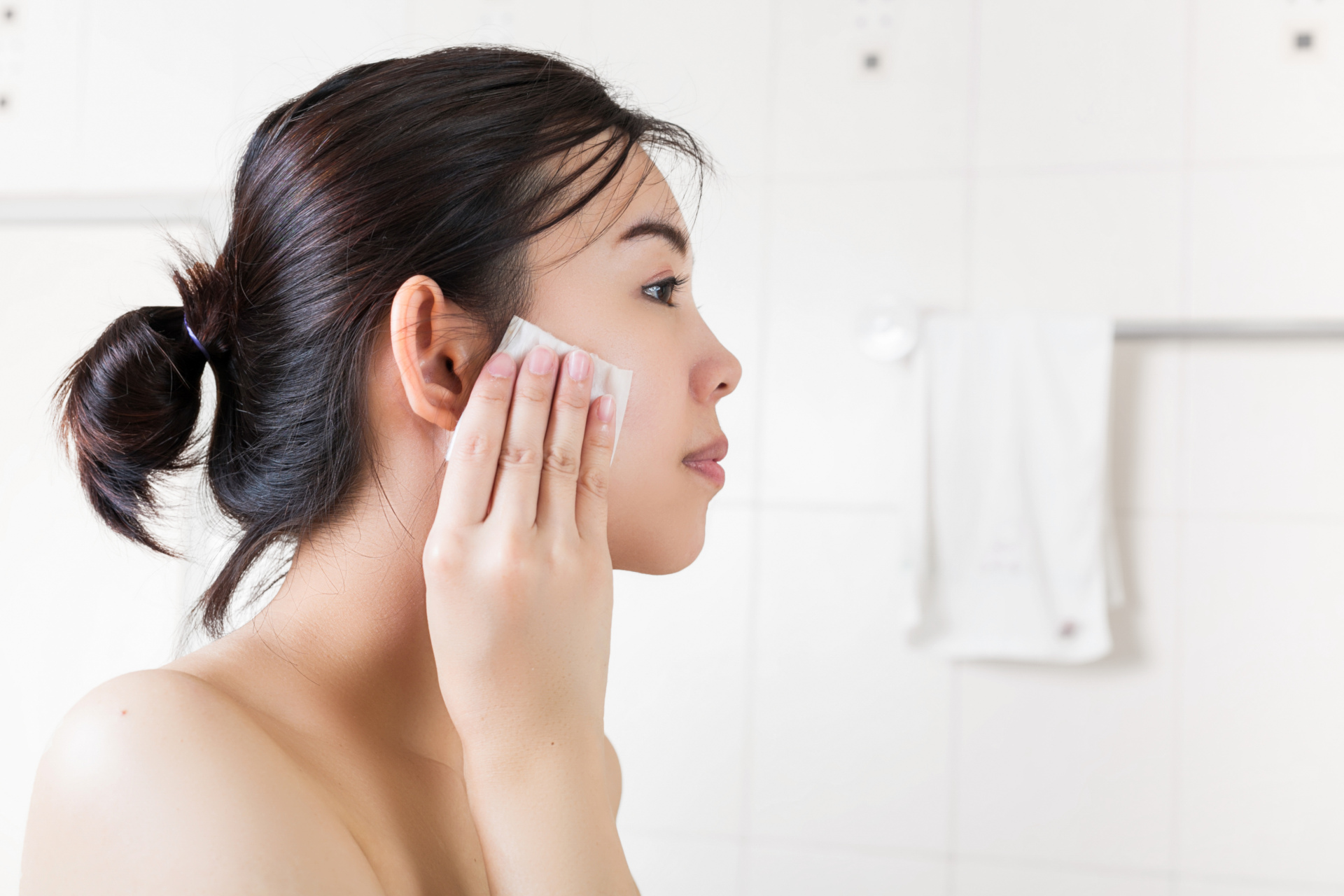 Woman using makeup wipe to clean face