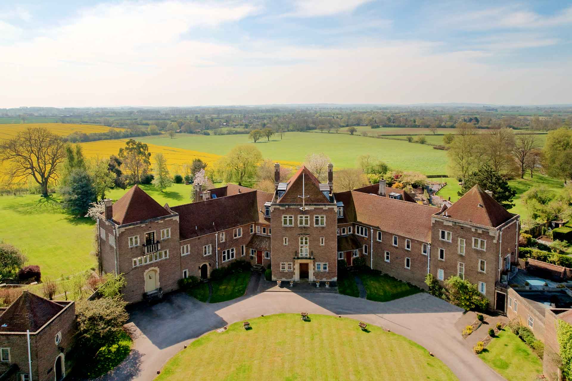 Aerial view of country manor set in sprawling grounds.