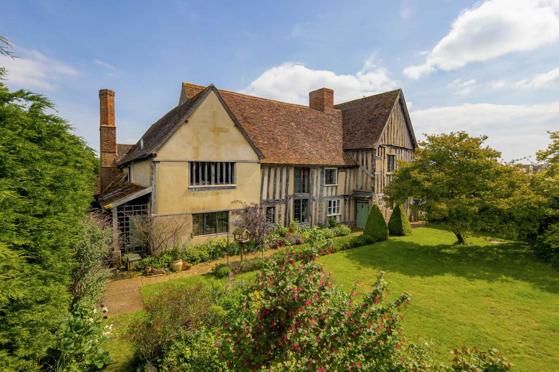 Timber-framed detached house with gardens.