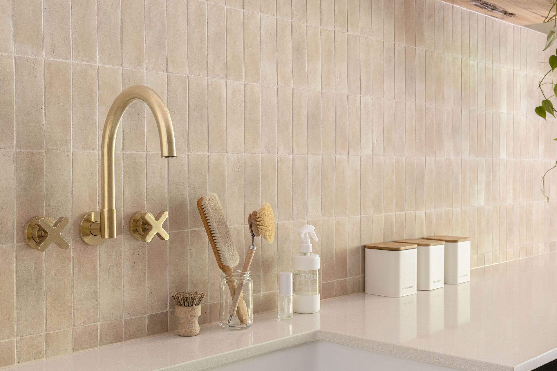 Contemporary kitchen with gold taps and cream tiles