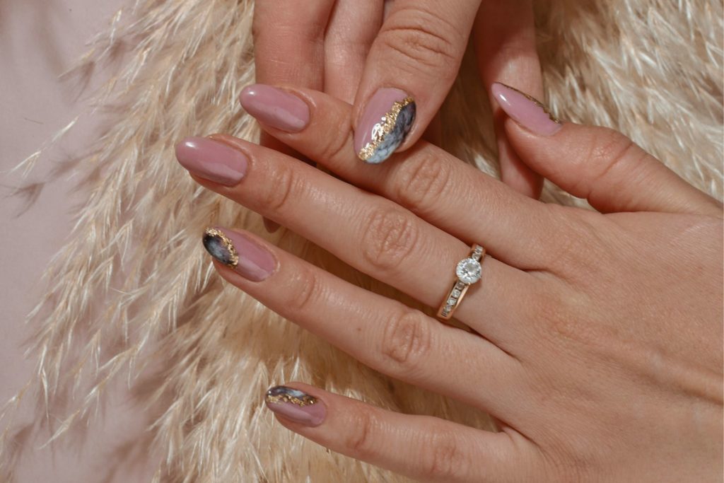 Pink chrome nails with grey and white marble accents.