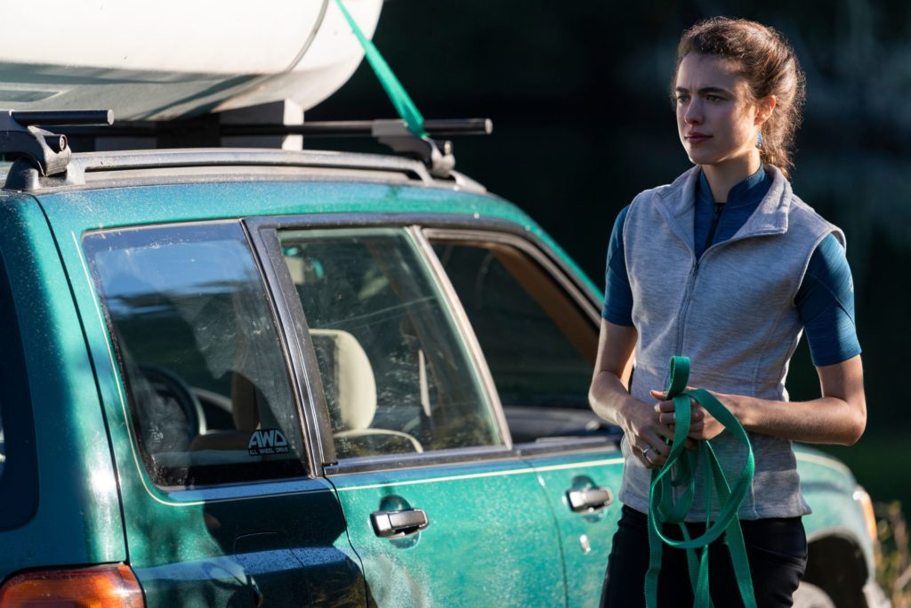 Margaret Qualley standing beside a green car in 'Maid'