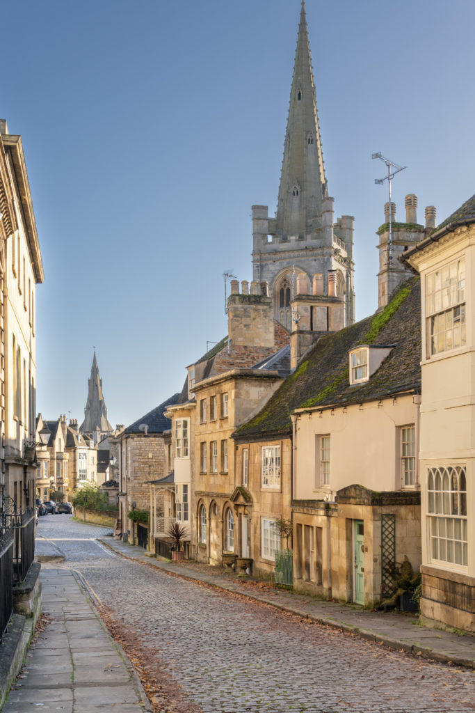 The historical market town of Stamford in Lincolnshire England looking down Barn Hill with St Marys and All Saints churches in the background