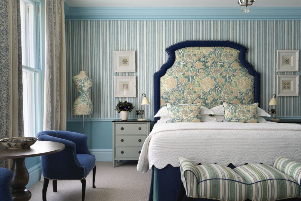 Kit-Kemp designed blue bedroom with patterned headboard