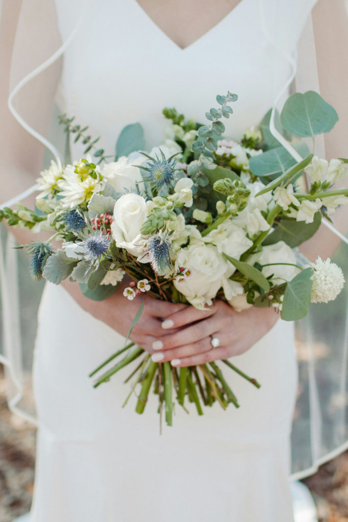 Close up of bride with white nails holding bouquet