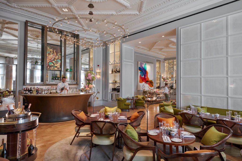 Dining room with panelled walls, mirrored bar and floral decor.