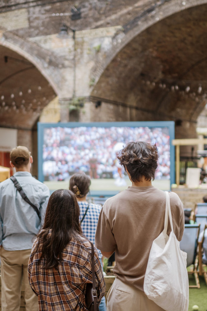 Two people watching a screen in Borough Yards, London