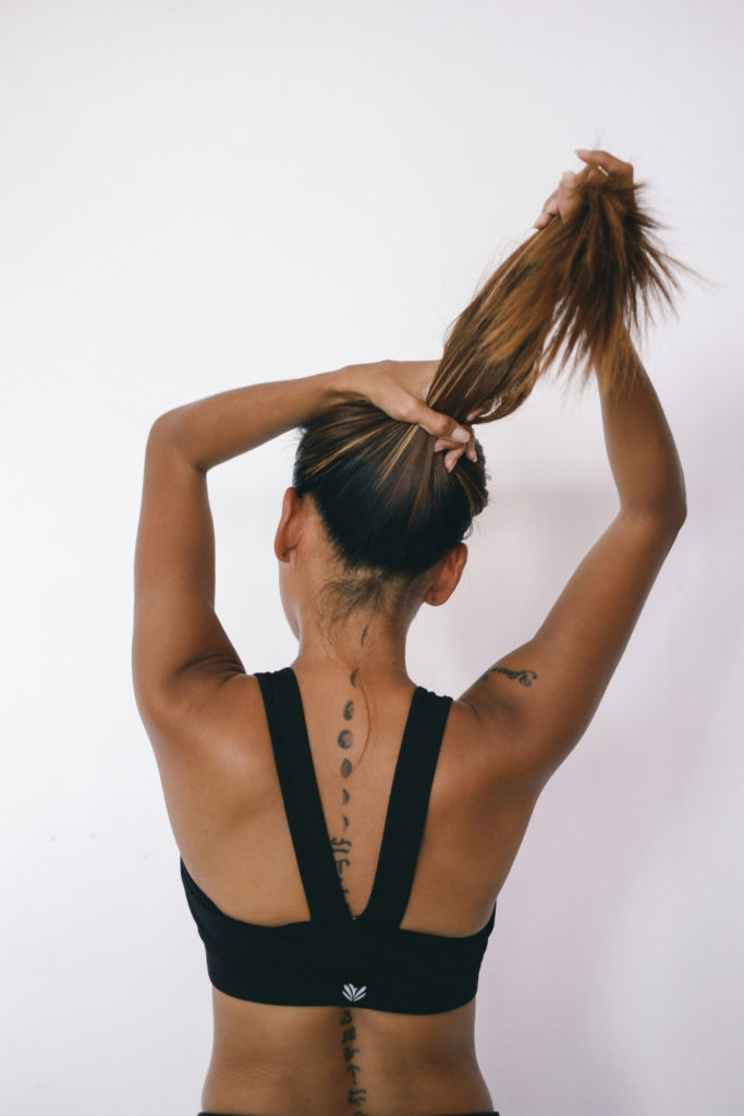 Woman putting hair up at the gym