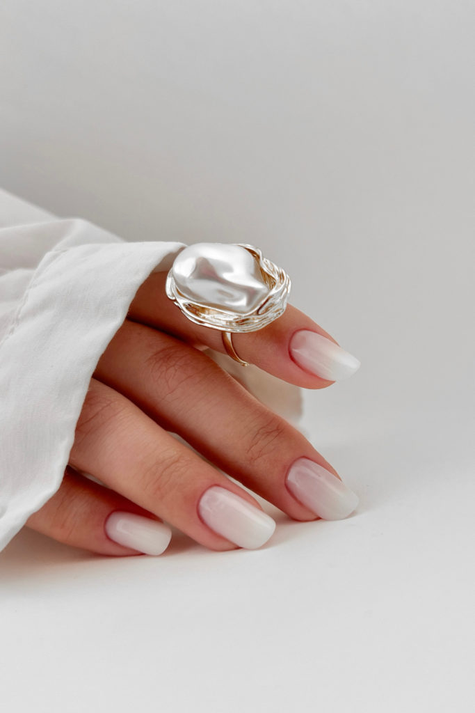Hand with pearl ring and neat nails