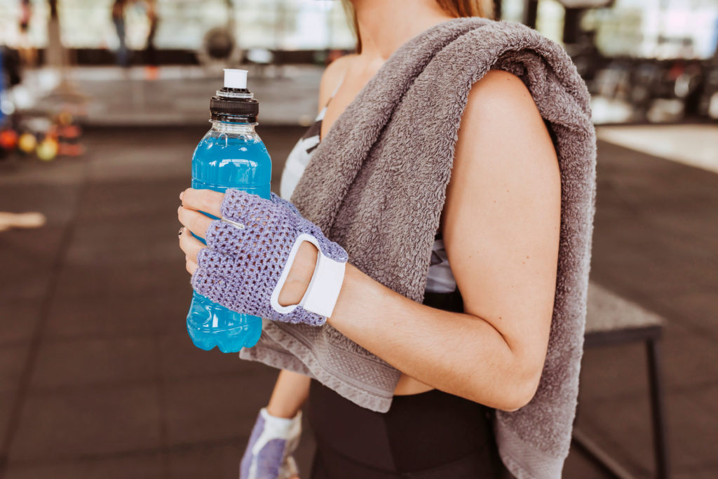 Woman drinking a sports drink in the gym