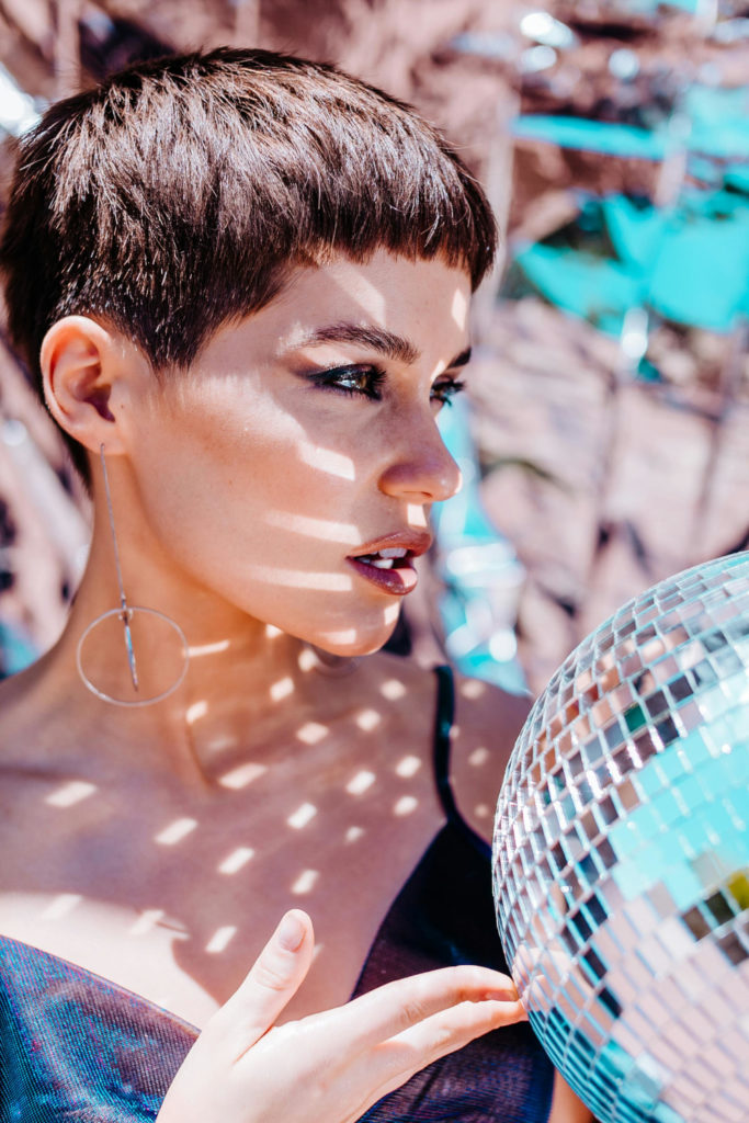 Woman wearing blush, holding disco ball