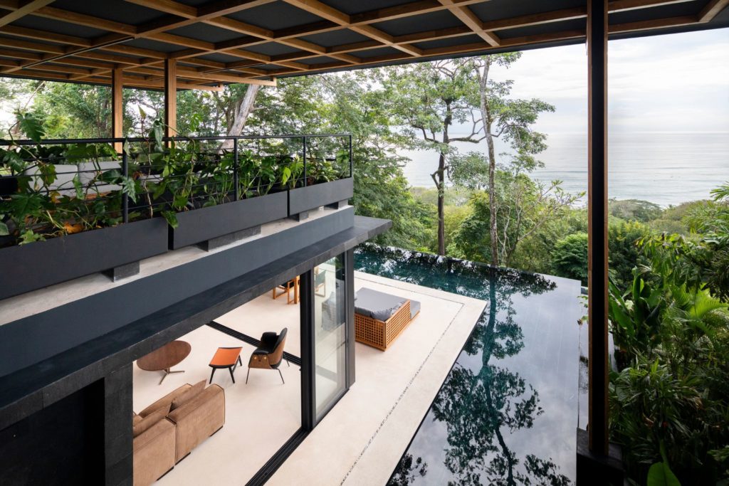 Jungle compound with floor-to-ceiling windows and a wraparound infinity pool