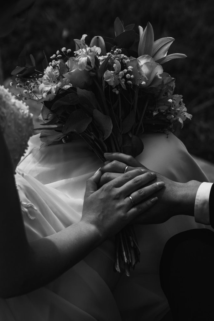 Two hands holding a wedding bouquet