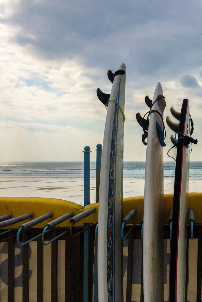 surf boards at Fistral Beach, Newquay in Cornwall on a breezy early Summer day