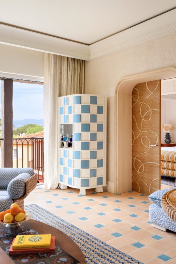 Hotel suite with blue chequerboard closet, blue armchair and views of St Tropez