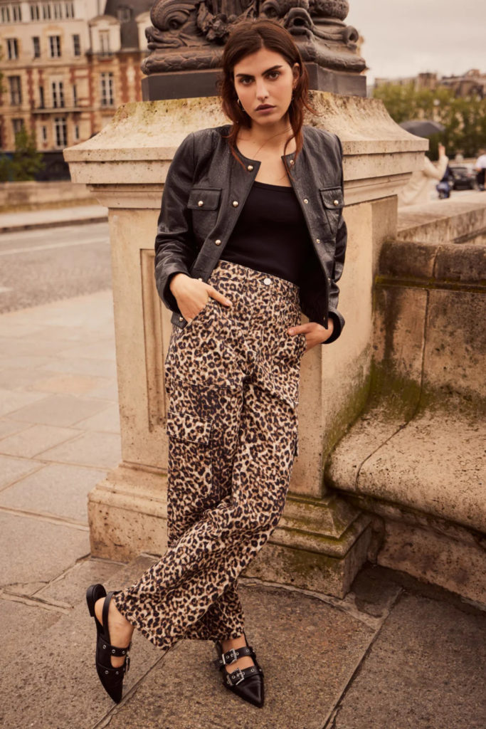 Woman leaning on stone wall in city