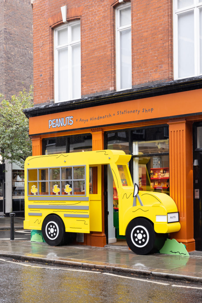 Yellow bus attached to orange shop front | Peanuts x Anya Hindmarch Pop-Up