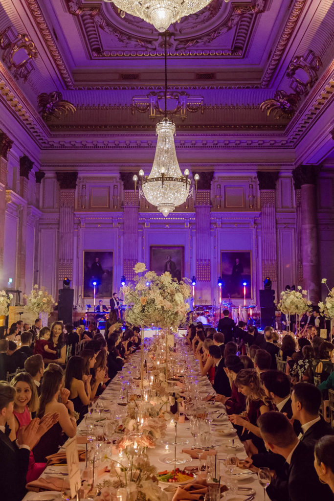 Wedding guests gathered around long tables