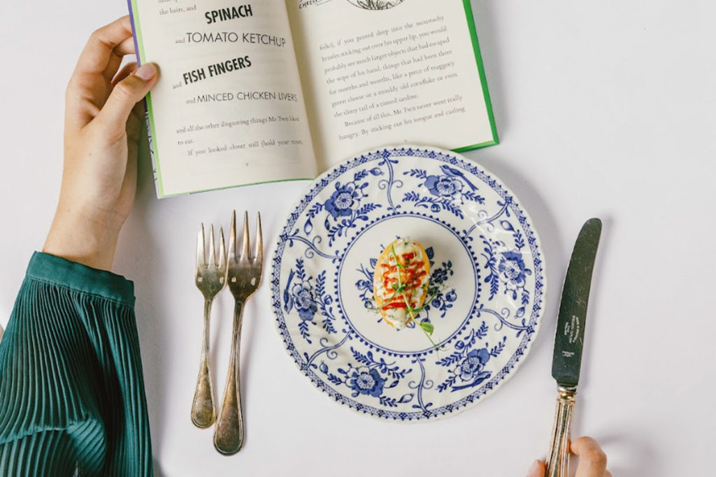 A plate of food beside a Roald Dahl book