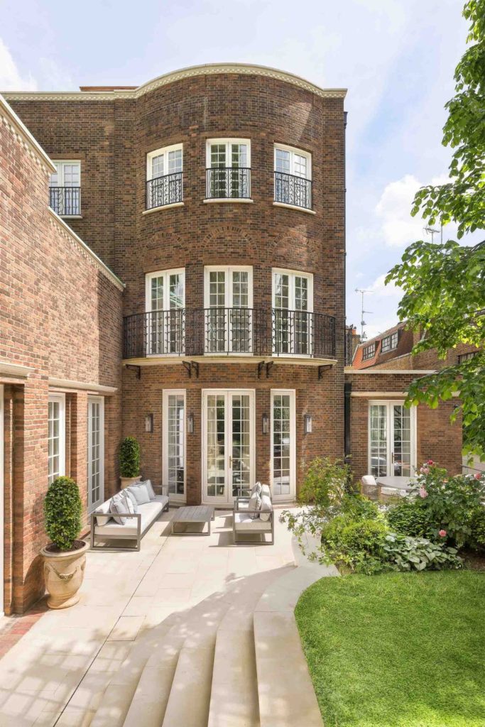 Brick mansion with raised lawn and curved facade