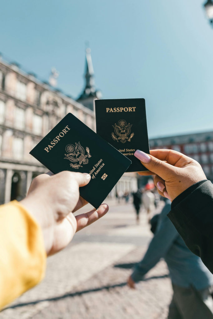 Two people holding their passports