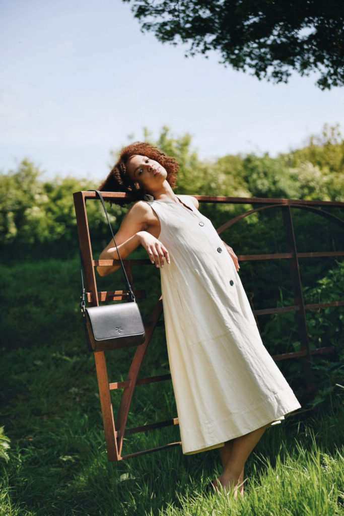 Woman leaning against gate outdoors