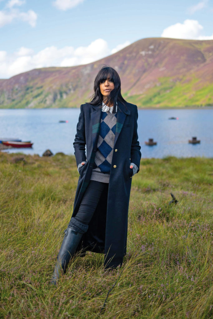 Claudia Winkleman in long coat and country clothing in the highlands