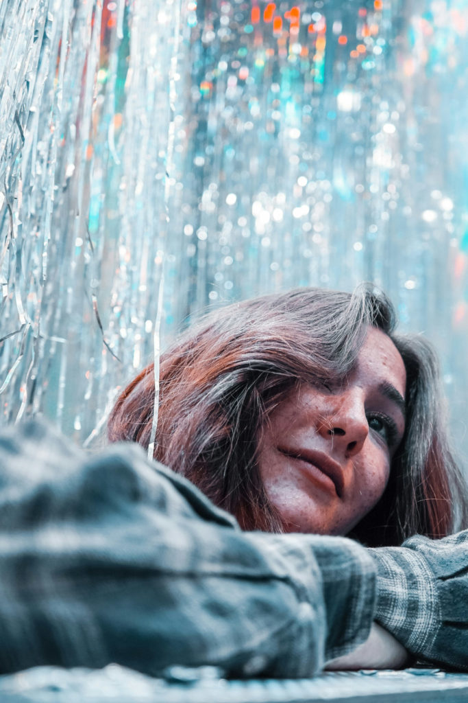 Woman with brown hair surrounded by silver tinsel