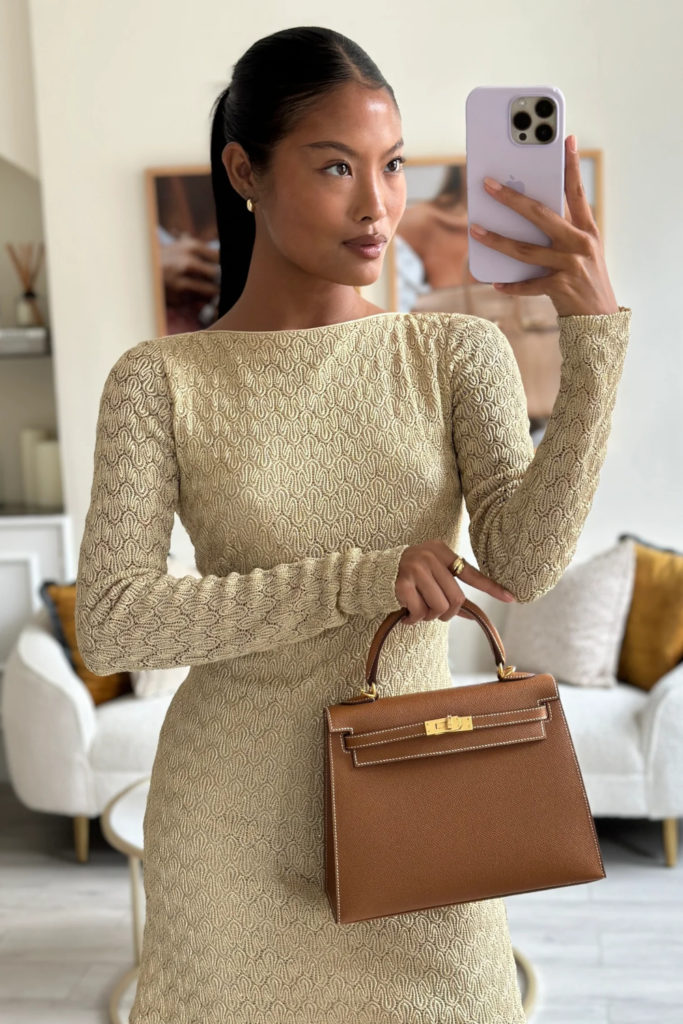 Woman in brown dress holding brown handbag | pre-loved investment piece