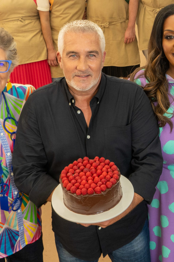 Paul Hollywood holding the Great British Bake Off cake