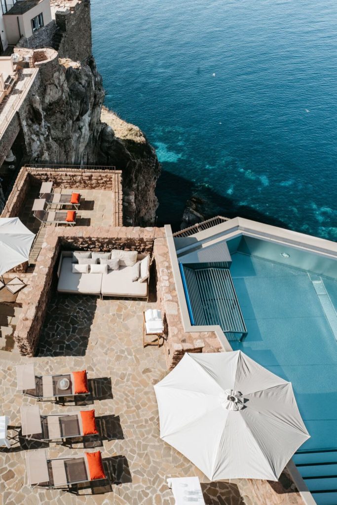 Aerial view of Tuscan cliffside hotel with pool