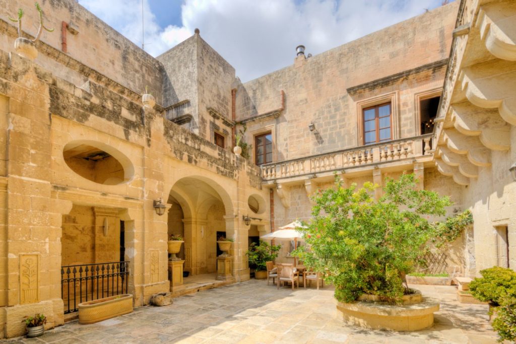 Palazzo exterior with stone walls and a courtyard