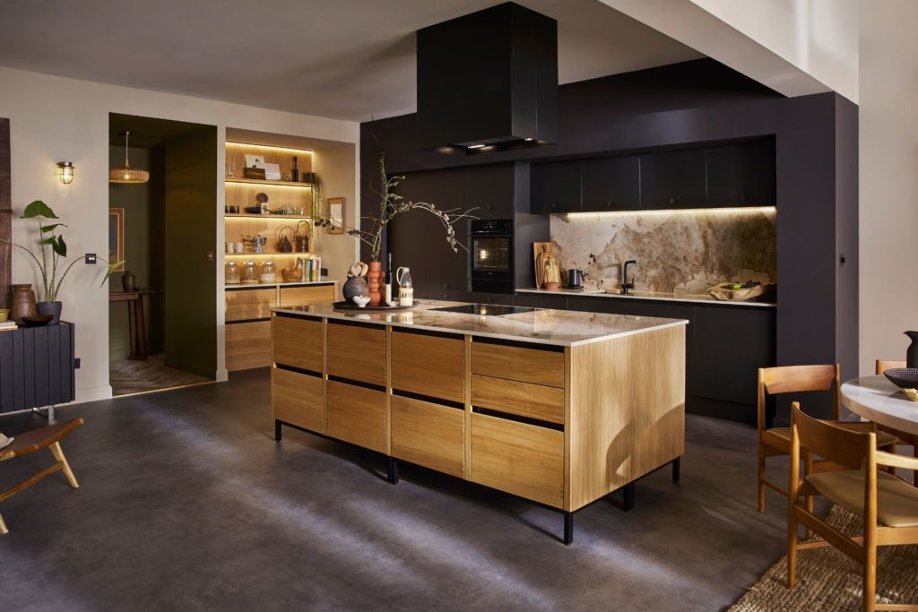 Kitchen with light wooden cabinets, white marble countertops and black wall units.