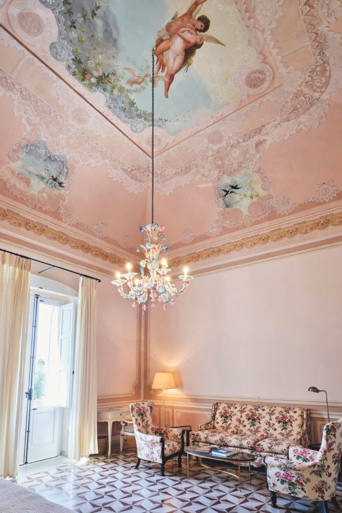 Lobby with marble tiled floor, chandelier and pink ceiling fresco