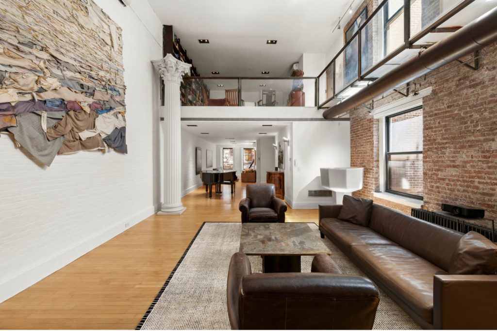 Loft apartment with exposed brick walls and brown leather sofas