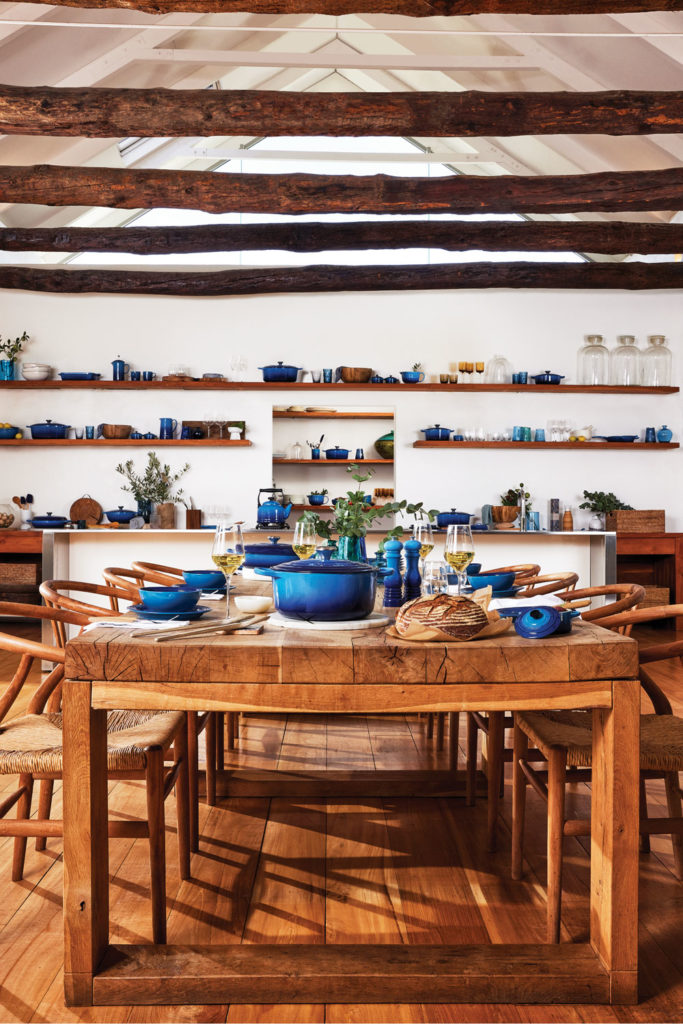 A wooden kitchen with lots of Le Creuset products