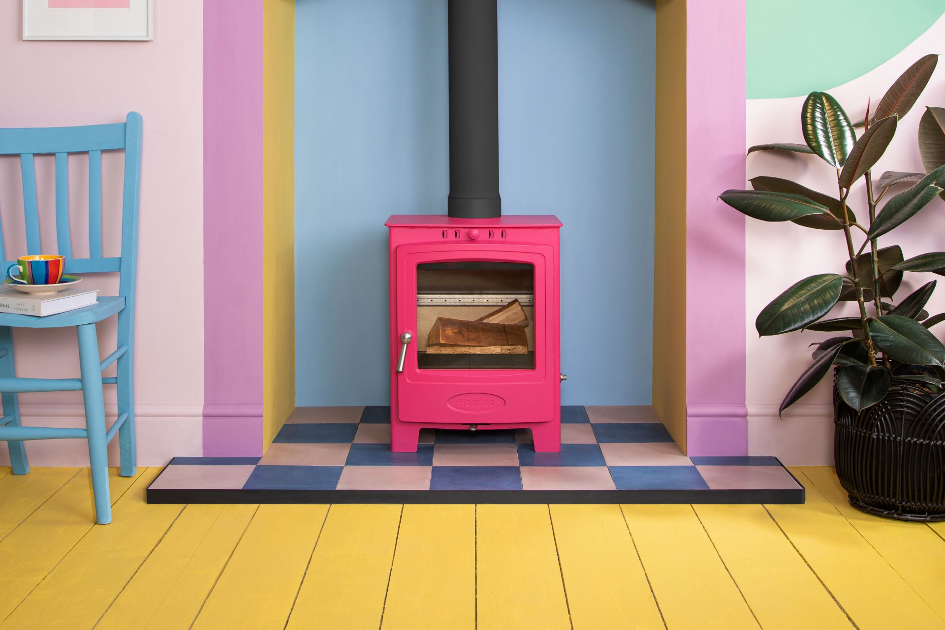 Living room with hot pink wood stove, yellow floors, a blue wall and lilac trim